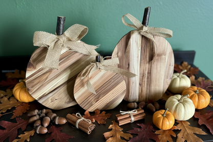 Flat lay of cedar pumpkins with acorns, cinnamon sticks, and fall leaves